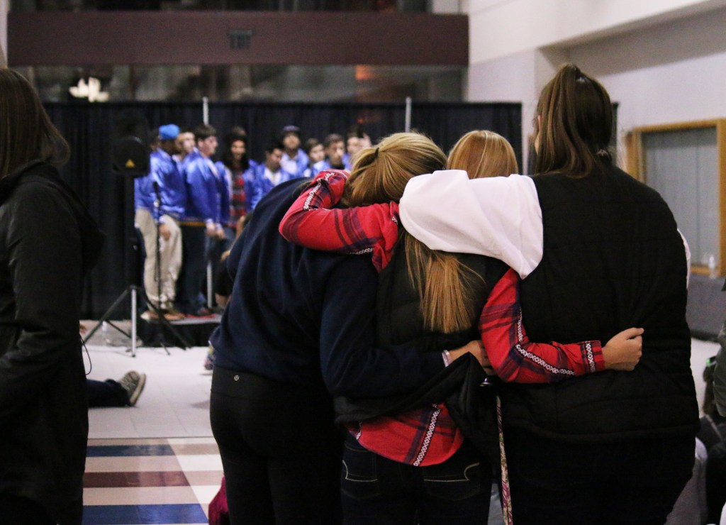 Friends rest on each other's shoulders while watching Fish n' Chips Acapella perform at CMU's Up All Night Event at 1 a.m. on Saturday, March 28, 2015. 