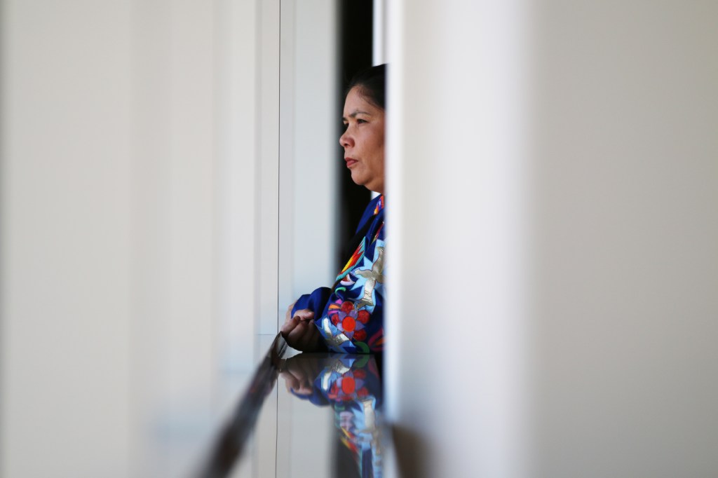 Dawn Sheroskey peers out the window of McGuirk Arena at the 26th Annual Celebrating Life Pow wow between dances on the Campus of Central Michigan University, Saturday, March 21, 2015. 