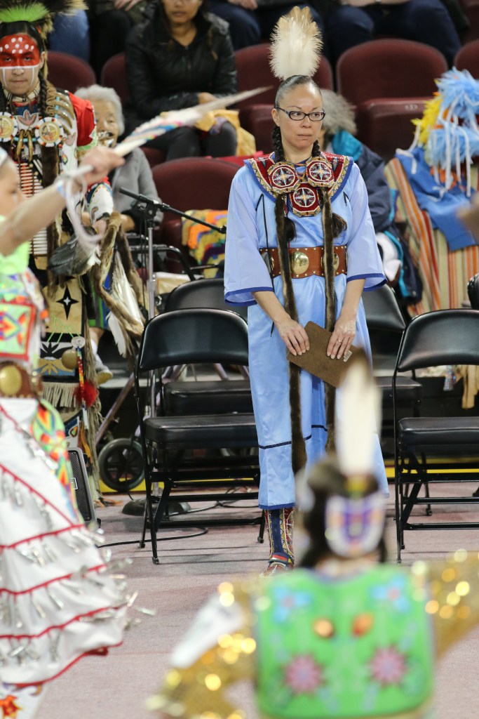 Lisa Hill judges a youth female dance at the 26th Annual Celebrating Life Pow wow in McGuirk Arena on the Campus of Central Michigan University, Saturday, March 21, 2015. She also competed in the fancy shall dance prior to judging. 