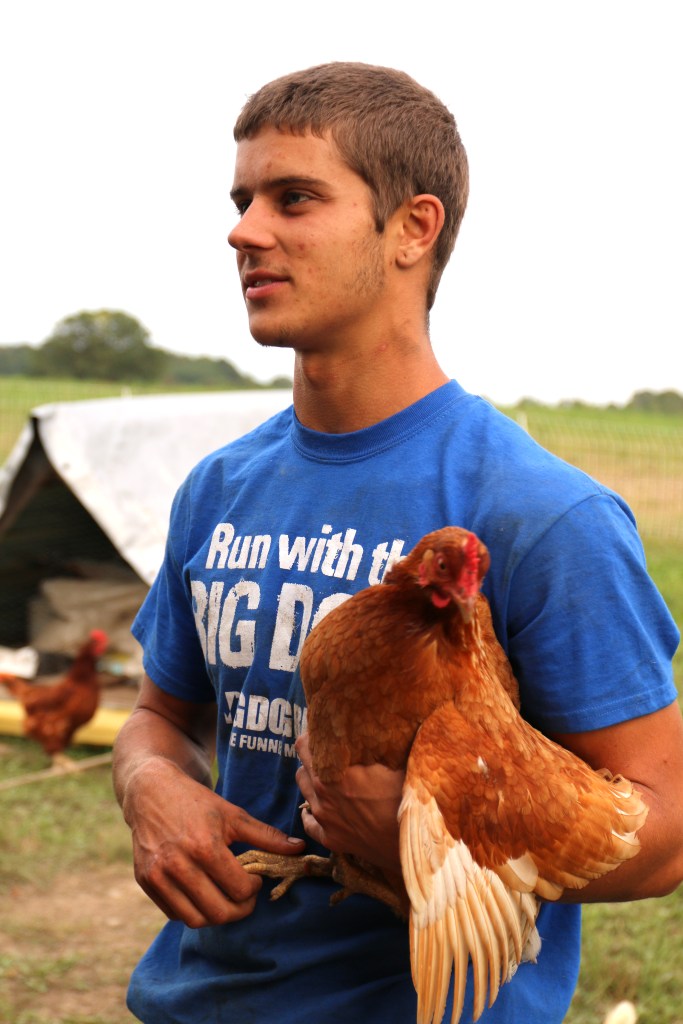 Kyle Staples holds an egg layer while telling a story to Ryley and Cameron on Sept. 30, 2015. 