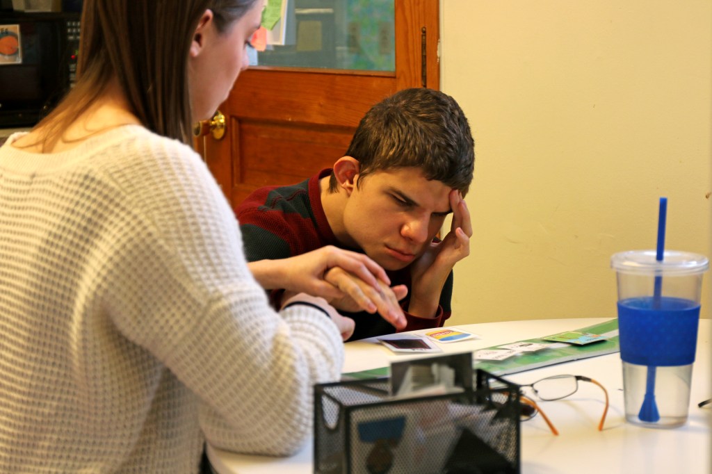 Emily Lane-Waters, a junior at CMU, helps Jacob Hartshorne, a 26-year old man with CHARGE syndrome select his schedule for the day with image cards on Monday, Oct. 27, 2015. Jacob, who is deaf and partially blind has caretakers with him 24 hours a day in his home in Mt. Pleasant, Michigan.