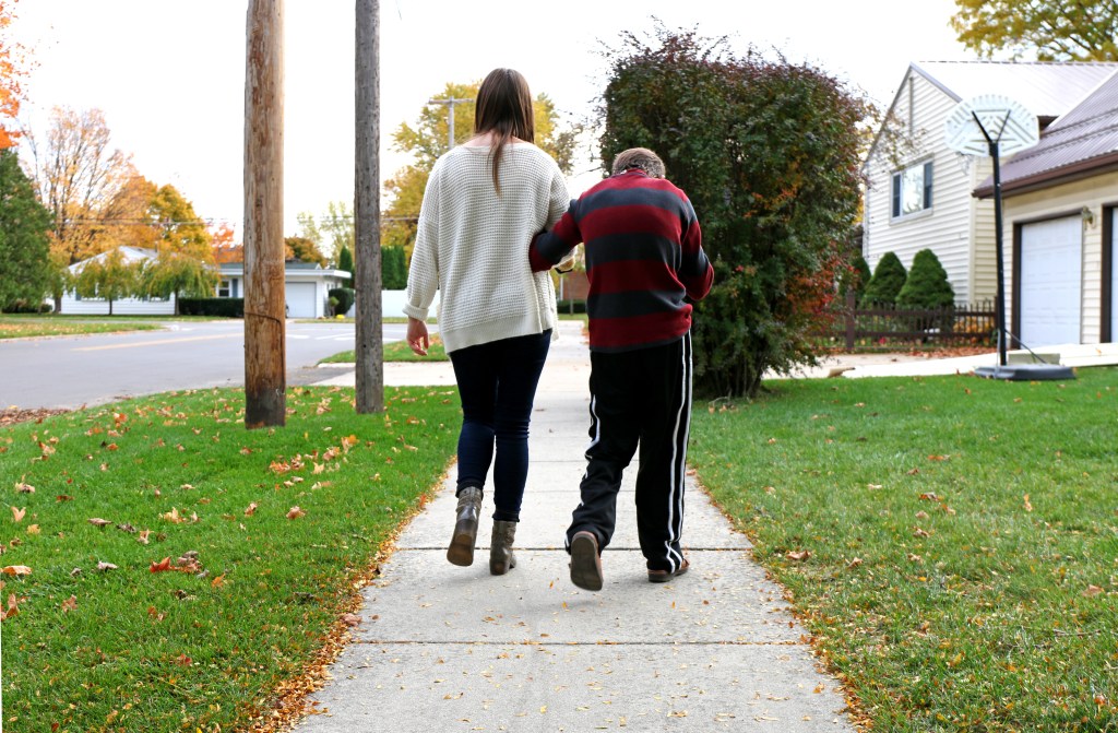 Emily Lane-Waters, a junior at CMU, walks Jacob Hartshorne, a 26-year old man with CHARGE syndrome to his parent's home on Monday, Oct. 27, 2015. Jacob lives in his own home in Mt. Pleasant, Michigan with 24 hour caretakers and frequently visits his parents home next door.  "I don't consider this work. Just hanging out with Jake calms me more than stresses me,"  Emily shared. 