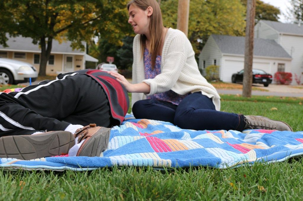Emily Lane-Waters, a junior at CMU, lays on the front lawn with Jacob Hartshorne, a 26-year old man with CHARGE syndrome on Monday, Oct. 27, 2015. Jacob, who is deaf and partially blind has caretakers with him 24 hours a day in his home, 920 S. Brown Street, in Mount Pleasant, Michigan.