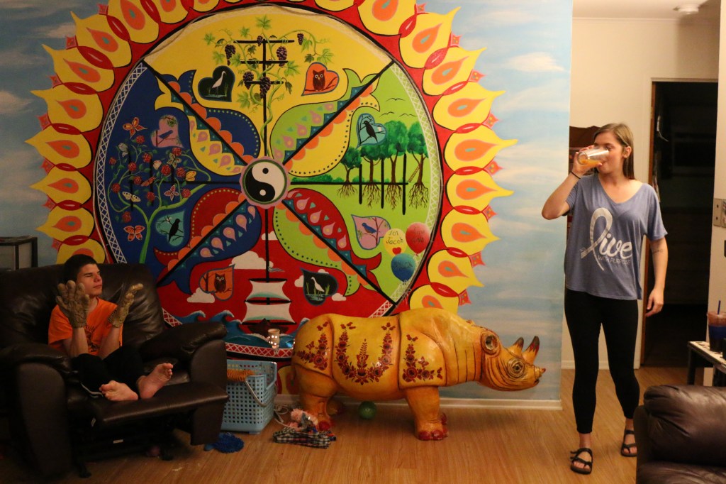 Emily Lane-Waters smiles at Jabob Harthorne while he plays with his halloween gloves on Nov. 3, 2015. Jacob's house is bright and colorful, and the main wall displays a bright mural.